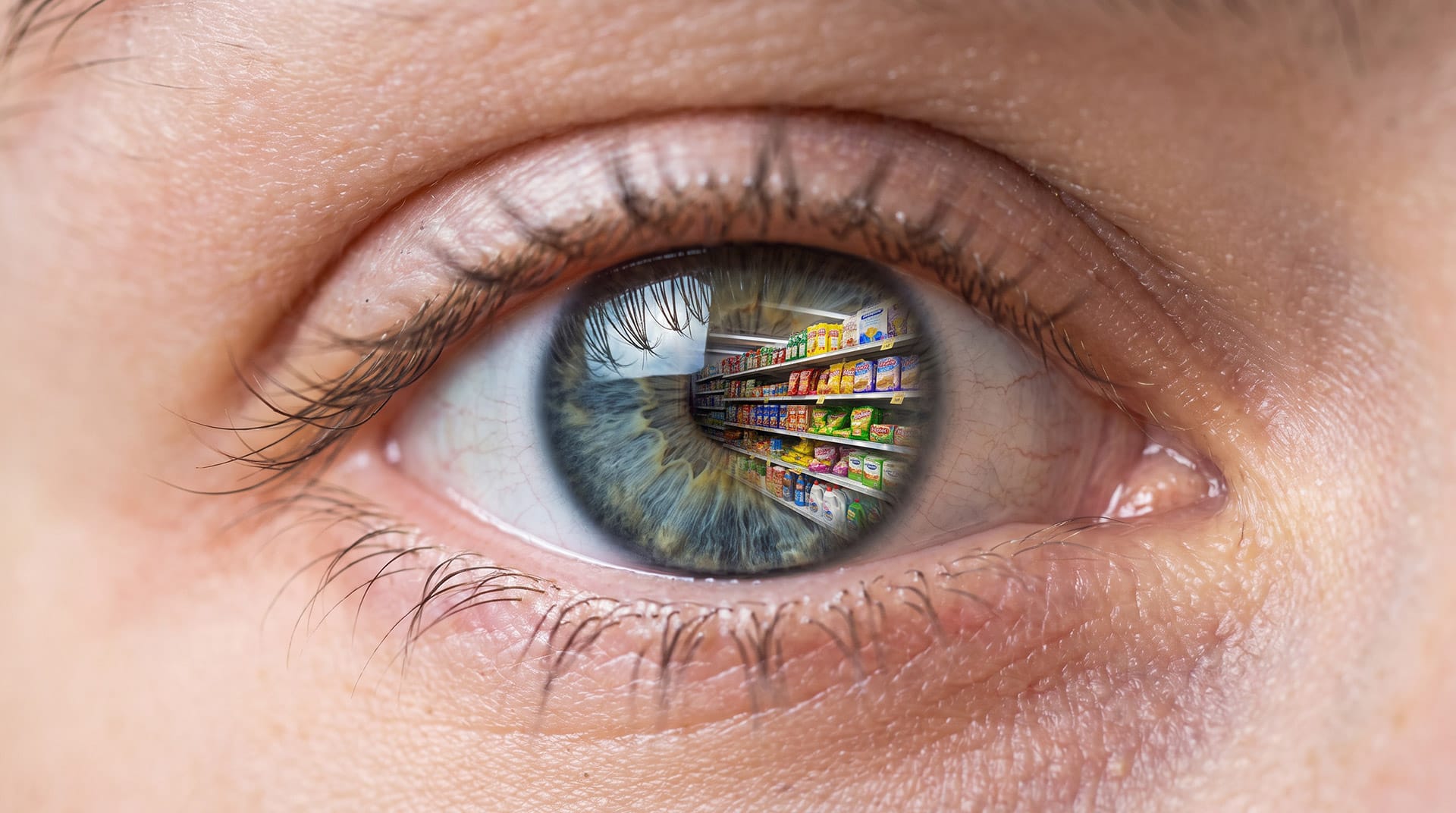 Ochi uman cu reflexia unui raft de magazin, ilustrând atenția vizuală în neuromarketingul de retail