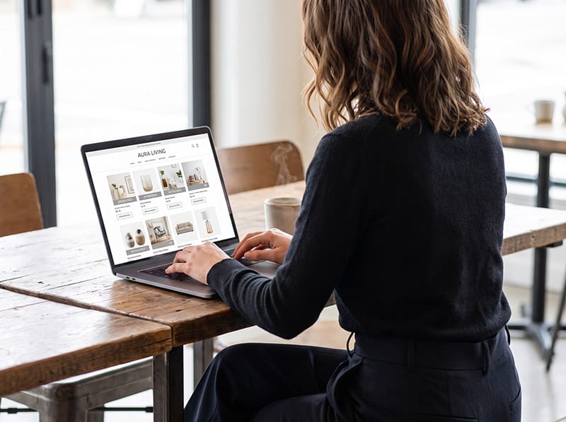 Shopper online - produse și poziții sponsorizate Femeie care face cumpărături pe laptop într-un magazin online, analizând mai multe produse și poziții sponsorizate integrate în rezultatele de shopping.